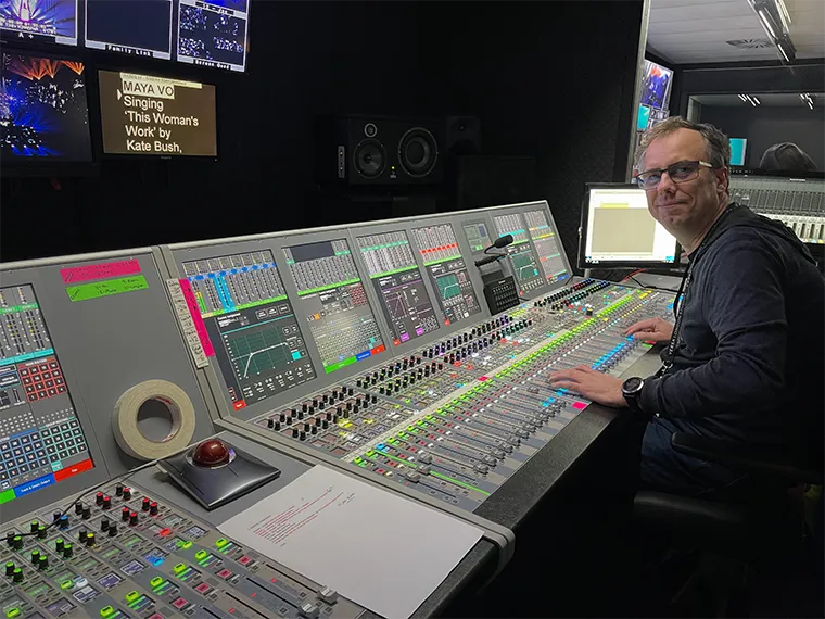 Ben Holland at a large mixing desk in a sound control room.